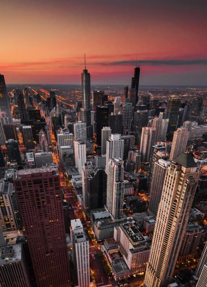 over the chicago skyline with the horizon in the background as dusk sets in