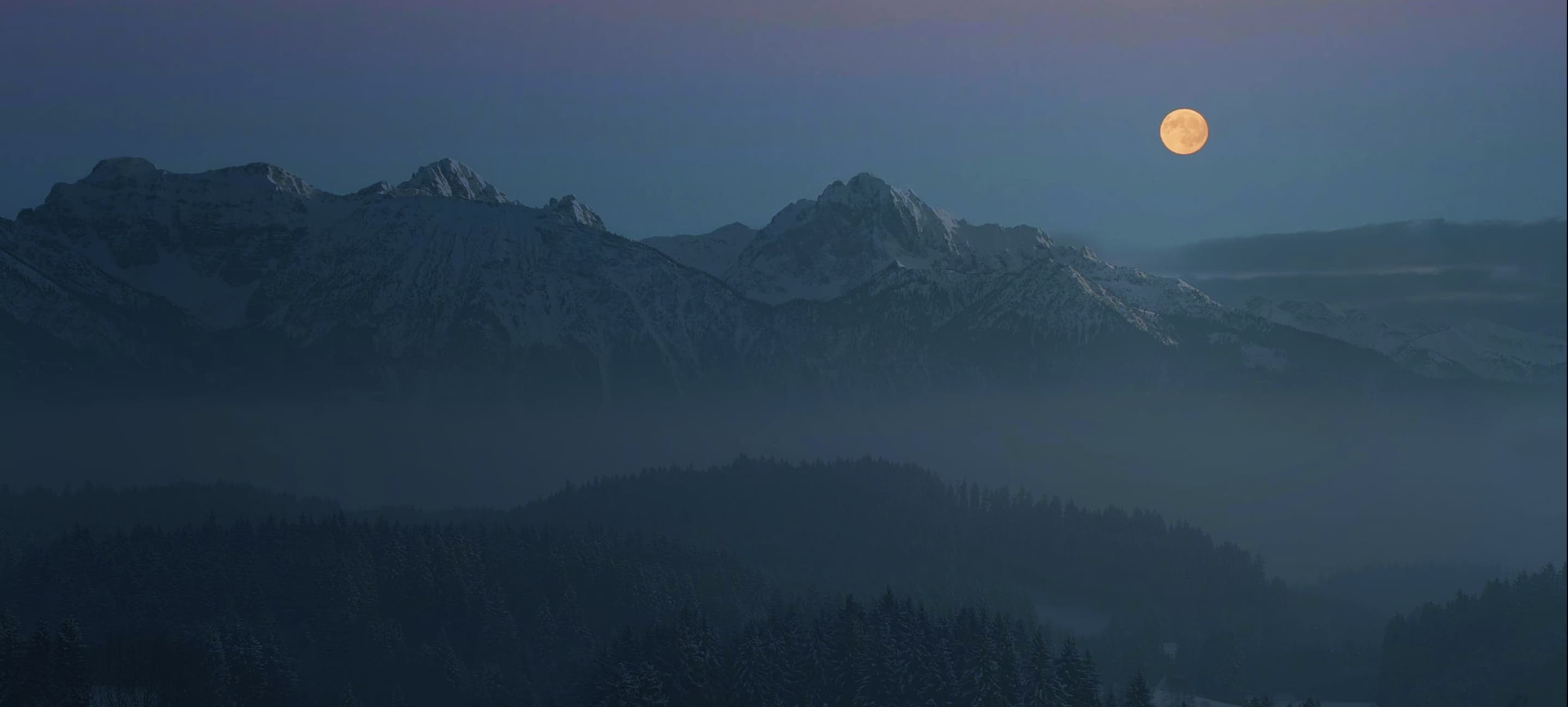 bright full moon over a mountain range